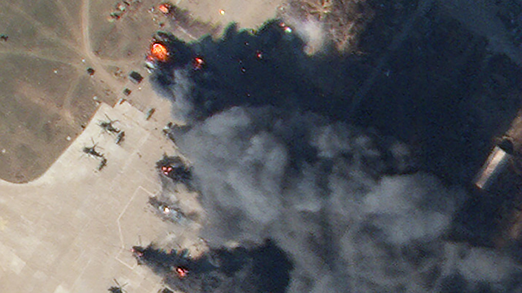 In an enlarged portion of the image, helicopters can be seen burning. 