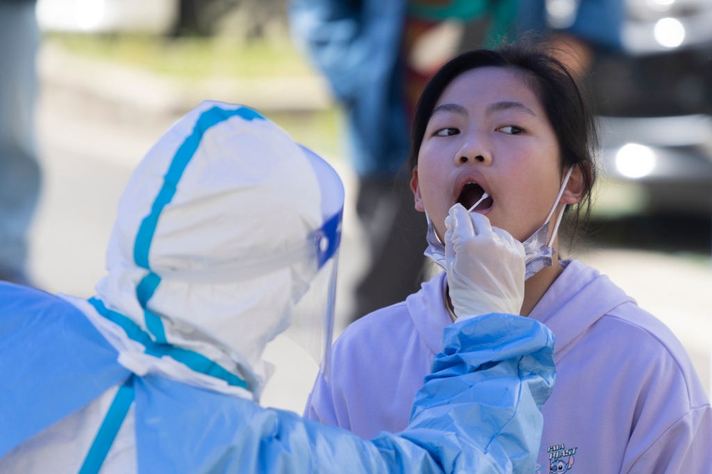 A girl is swabbed in her mouth for a COVID-19 test in Shanghai, China on April 22, 2022.