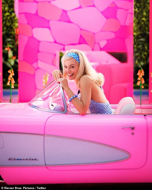 Stunning: The 31-year-old Australian actress looked totally creative behind the wheel of a classic pink Chevrolet Corvette in front of what looks like a Barbie mansion