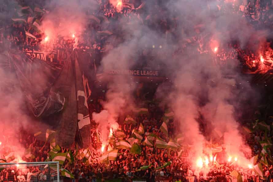 Feyenoord fans light their torches during the Europa League final against Roma.