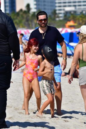 Miami, Florida - Scott Disick is a happy dad as we pick up the star spending time with his three kids Penelope, Mason and Wren in Miami.  Scott cruises in the water with his daughter Penelope and younger son Rain (who wears a Squid gaming mask) while Mason relaxes on a beach chair.  Pictured: Scott Disick, Penelope Disick, Rain Disick Backgrid USA Feb 22, 2022 USA: +1 310798 9111 / usasales@backgrid.com UK: +44208344 2007 / uksales@backgrid.com *UK Customers - Pictures Containing Children Please Pixelate Face Before Posting *