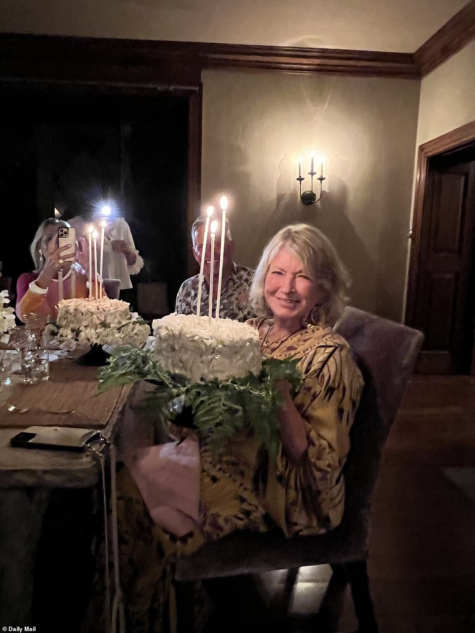 Glowing: Businesswoman poses with her cake to take another photo of her amazing bash