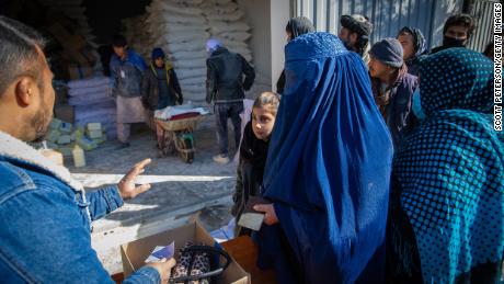 An Afghan woman receives her monthly ration of basic food items for her family from a World Food Program distribution point in the Jay Rais district, west of Kabul.
