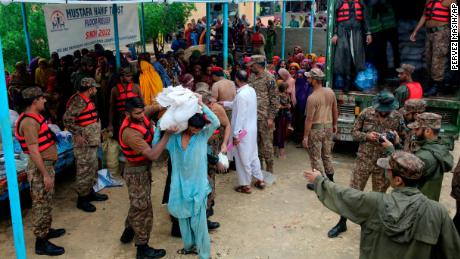 Army forces distribute food and supplies to displaced people at a relief camp in Jamshoro district, southern Pakistan, on August 24.