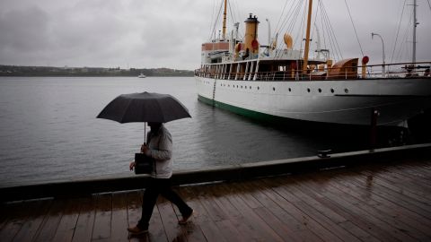 A pedestrian protects themselves with an umbrella while walking along the Halifax waterfront with rain before Hurricane Fiona makes landfall in Halifax, Friday, September 23, 2022.