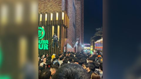 A man is seen climbing a building to escape the crowd in Itaewon, Seoul, on October 29. 