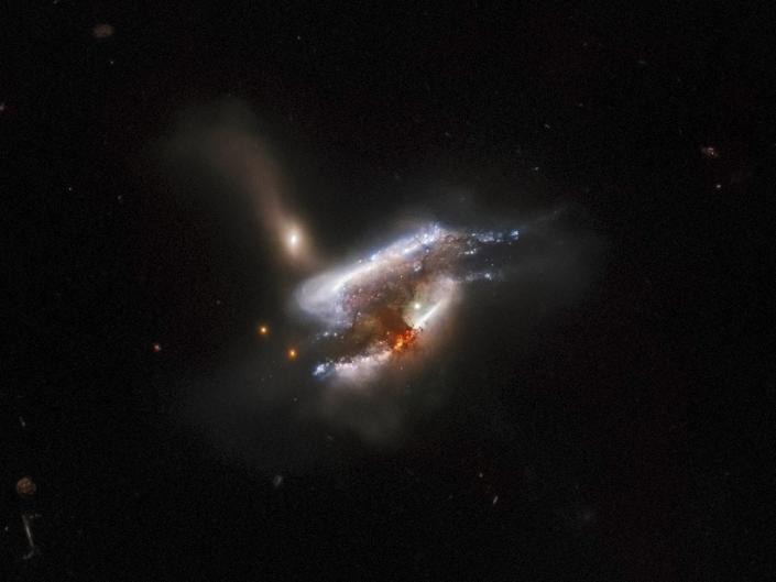 Three intertwined galaxies merge in black space