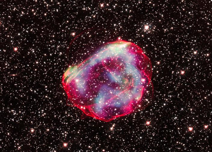 Supernova remnant of a shiny pink bubble against a background of stars